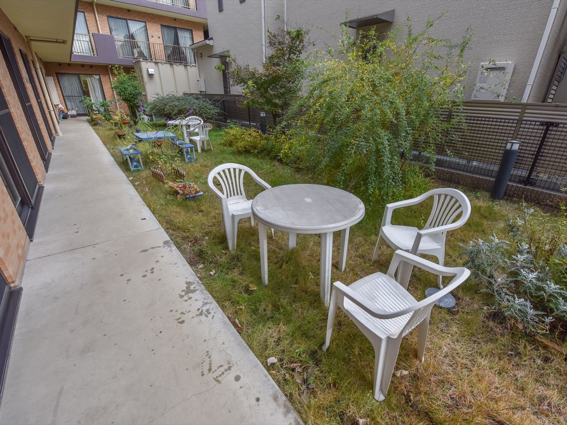 １階の居室から直接出られる庭はフェンスと建物本体で囲われていて、自由に使える座席類がいくつか並べられている。