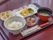 施設で入居者様に提供される食事。赤い膳に乗せられており、白米を主食に据え箸が付いてくる和食タイプになっている。