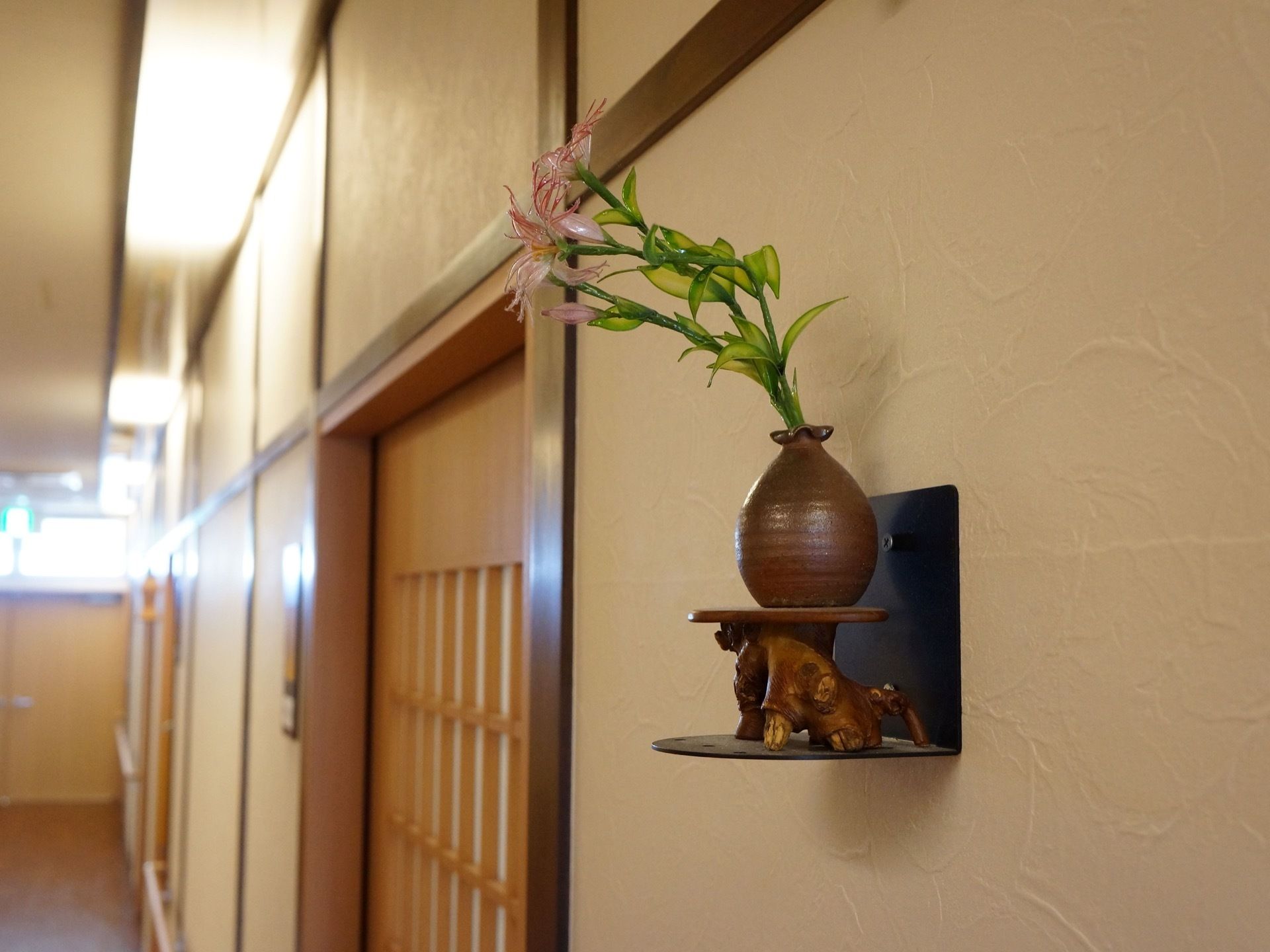 通路全体が和風の造りになっている。塗り調になっている壁には、和の壷に花を入れるなどして展示している。