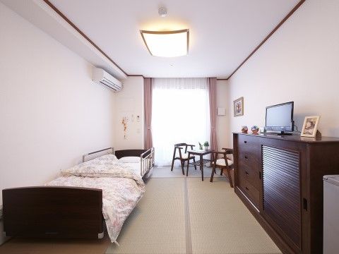 ロイヤルレジデンス新座の居室。畳のお部屋。濃いめのブラウンの家具を使用し、どこかレトロな居室です。