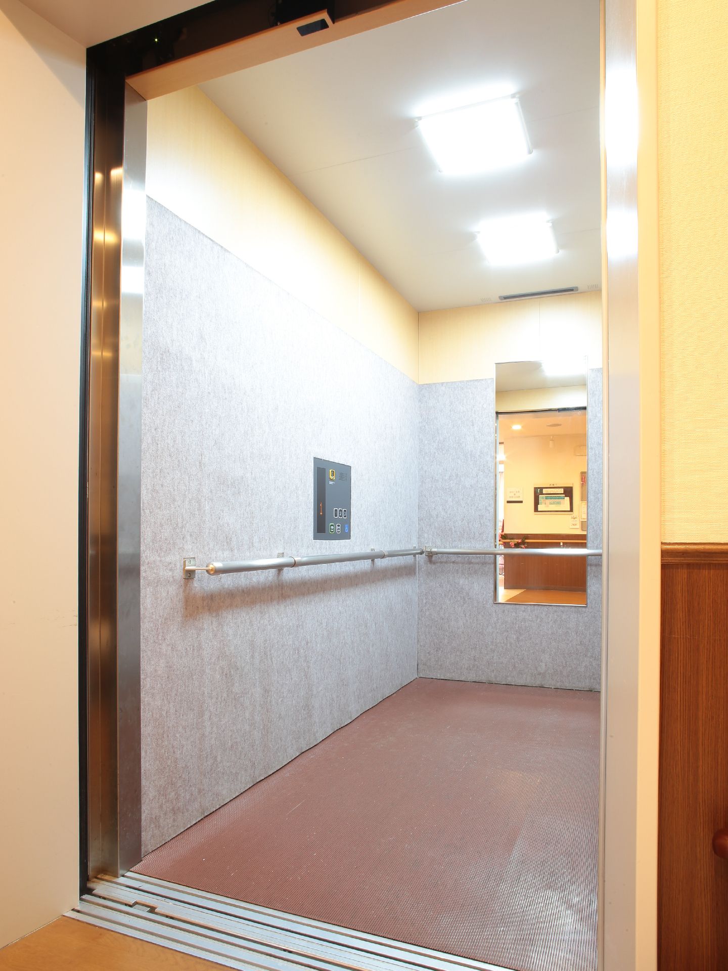 安全に乗り降りできる幅広く開閉する扉とゆったりと奥行があるエレベーター。中には手すりと鏡が設置されている。