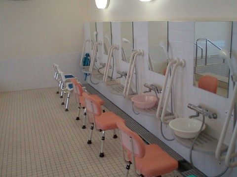 「ロイヤルレジデンス綾瀬」の浴室。オレンジ色のシャワーチェアを設置している。
