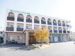 施設建物を前面から見たところ。３階建てになっており、それぞれの居室の前には目隠しを兼ねたフェンス付きのベランダが設置されている。
