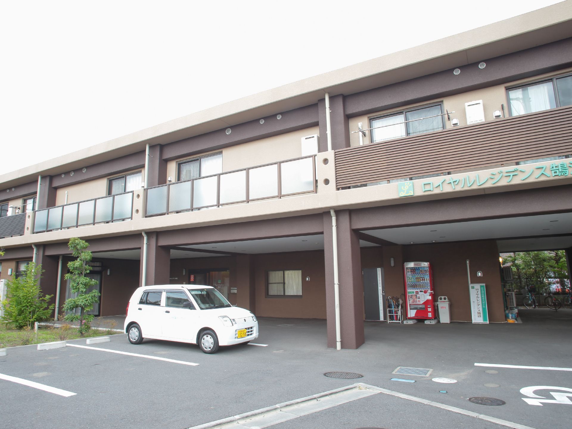 ブラウンの外壁がおしゃれな雰囲気がある施設の外観。建物の前には駐車スペースがあり、車椅子での移動も可能である。