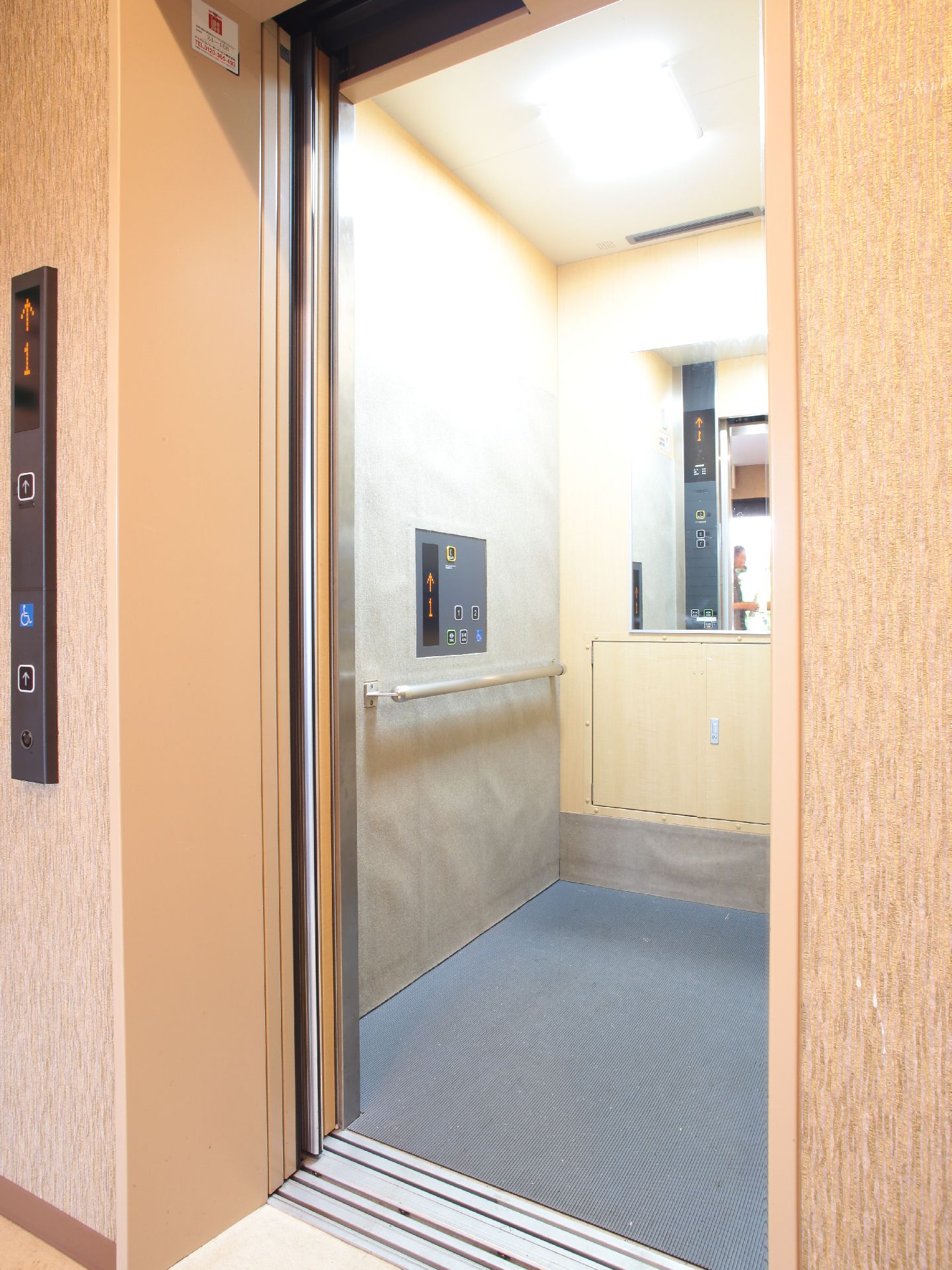 中には手すりが設置されており安全である。とても明るいエレベーターとなっている。車椅子の人も利用できる広さがある。