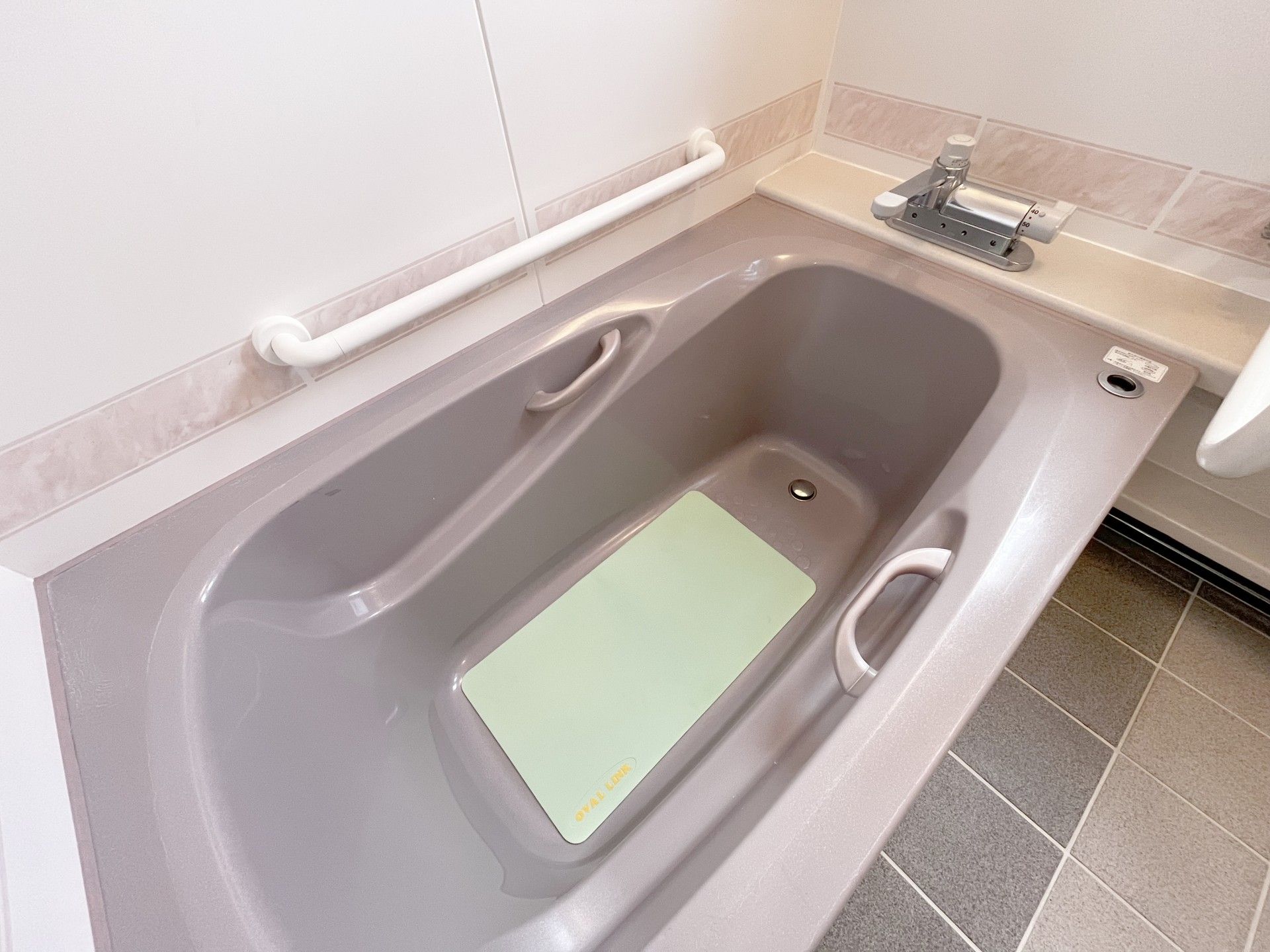 高齢男性の身体を支える女性ヘルパー