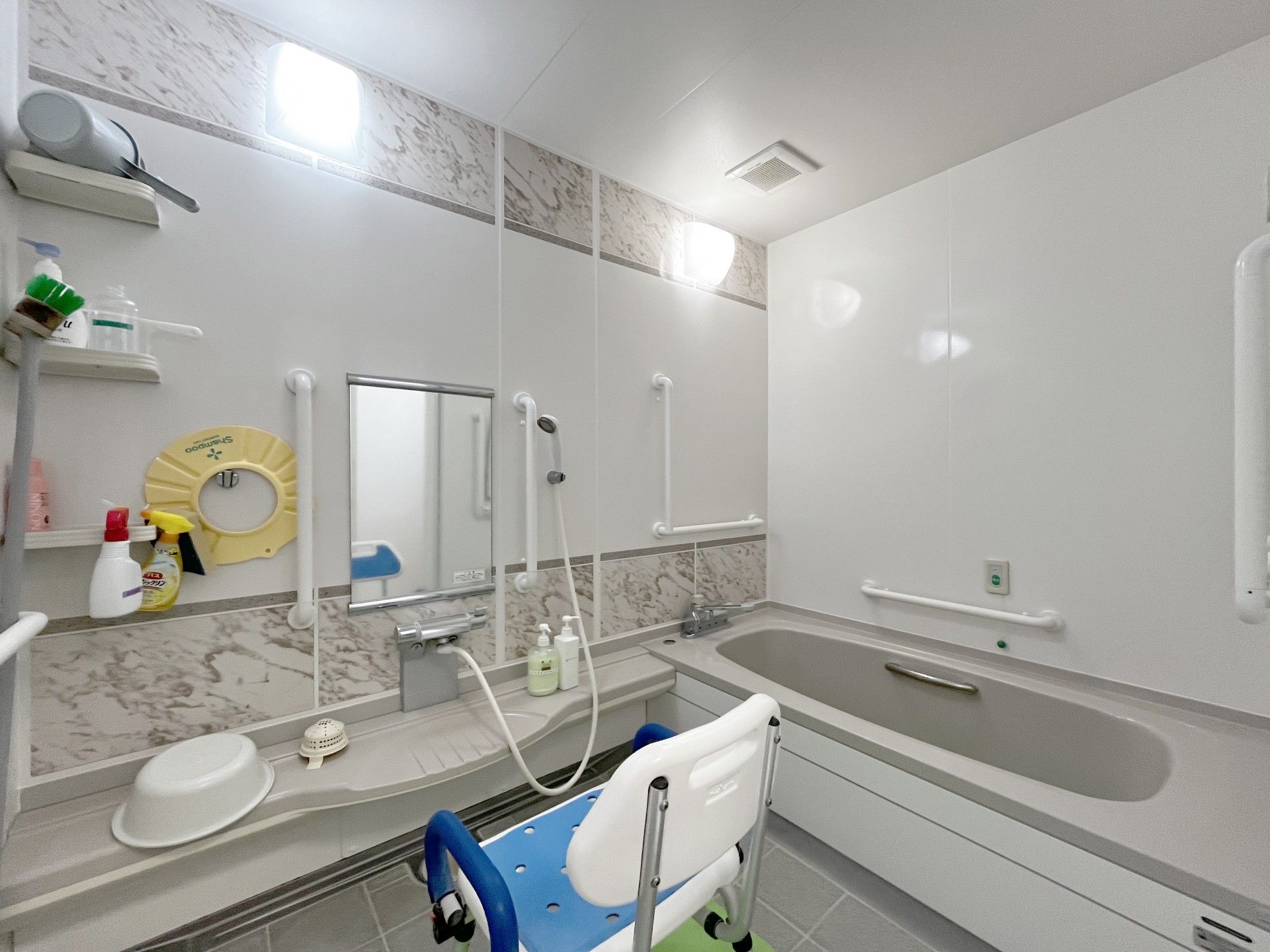 高齢女性の乗った車椅子を押す女性ヘルパー