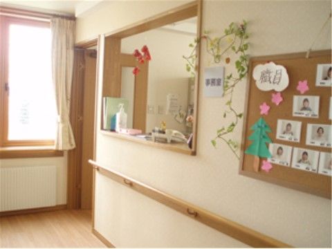 廊下の一角に事務室がある。廊下の壁にフェイクグリーンや紙で作った飾りを施し、明るい雰囲気を演出している。