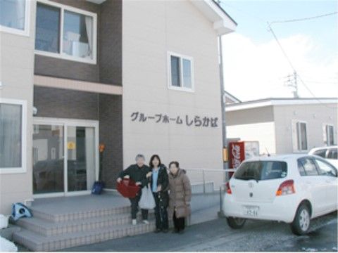 介護施設の前で写真を撮る入居者