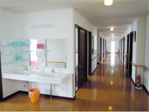 二つ並んだ洗面台は正面に鏡もあり、清潔に保たれている。廊下の壁伝いには手すりが設置されているので、安心して歩行できる。