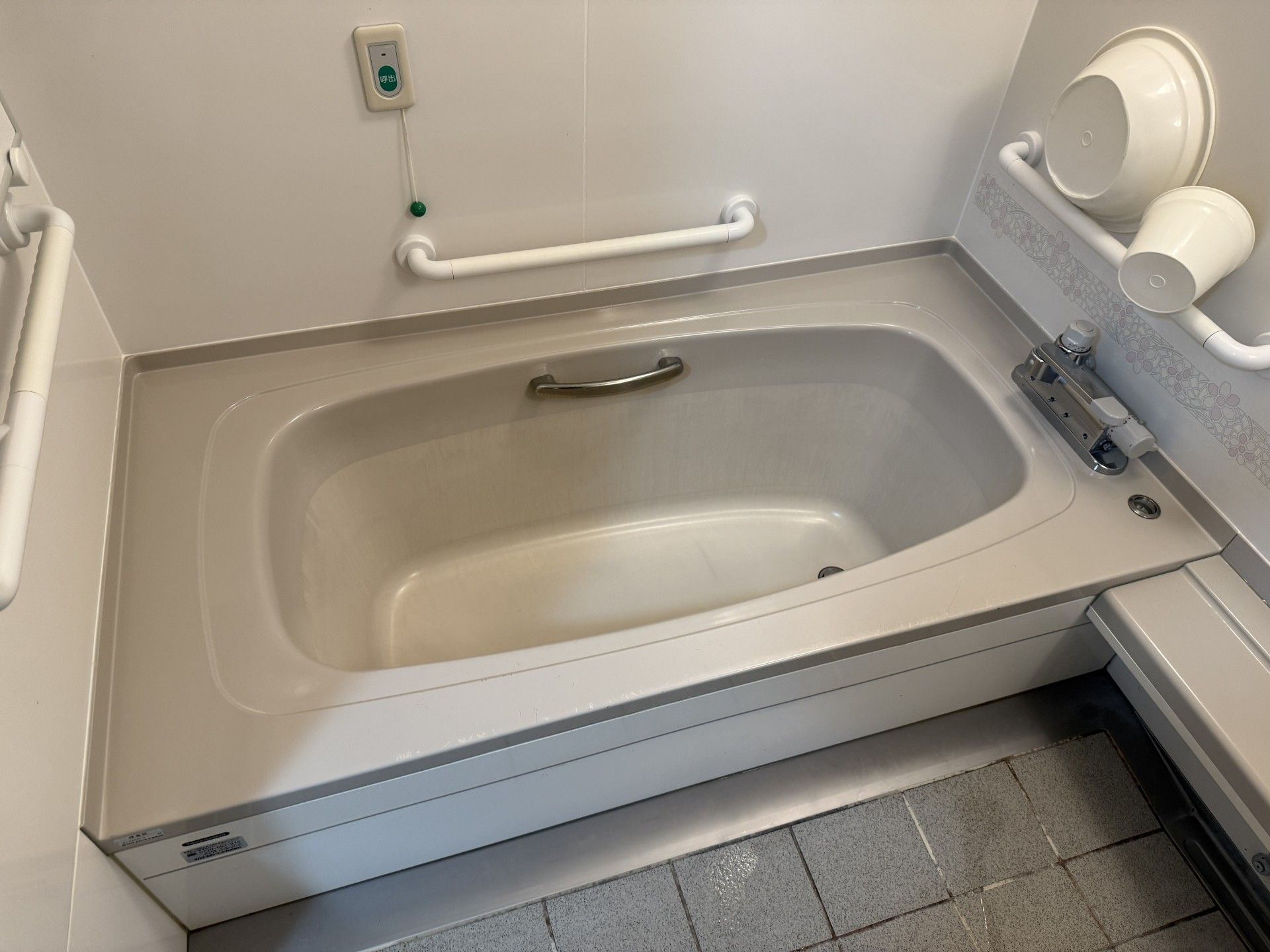 笑顔の介護士に囲まれた車椅子に座っている高齢女性