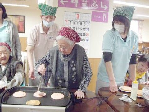 ホットプレートを使って料理をする、スタッフと入居者様たち
