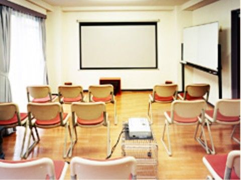 部屋の右奥にキャスター付きのホワイトボードがあり、正面にもホワイトボードがある。手前には映写機が置かれている。