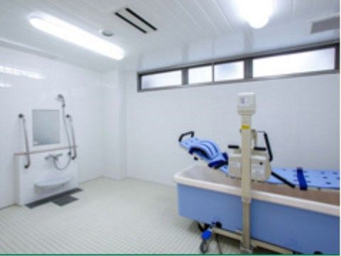 明り取りの小窓があり、浴槽にバスリフトが設置された浴室