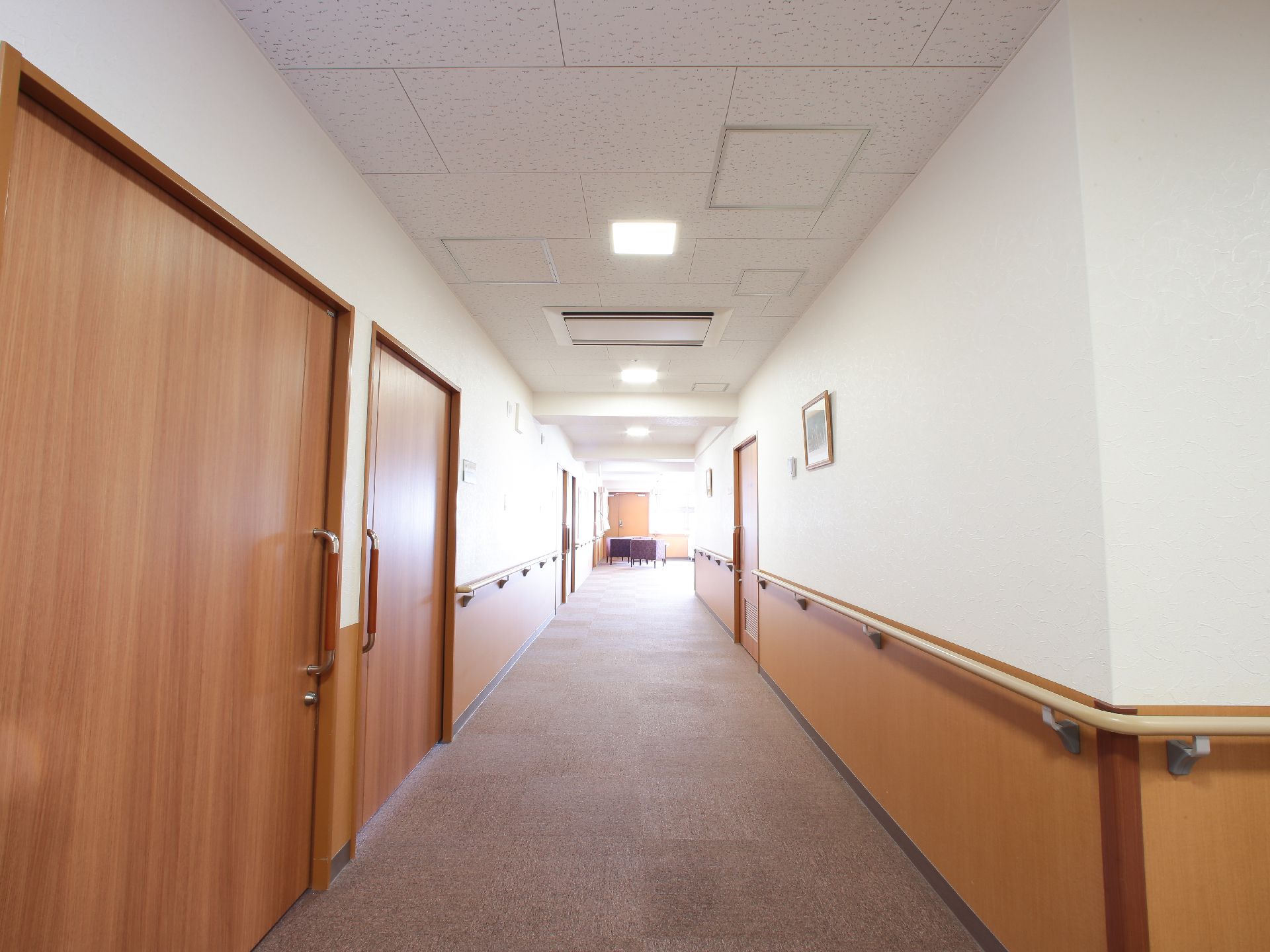 居室のドアは茶色でハンドルが取り付けてある。スライド式の開閉だから力が弱い方でも楽に開け閉めができる。ハンドル下に鍵がついている。