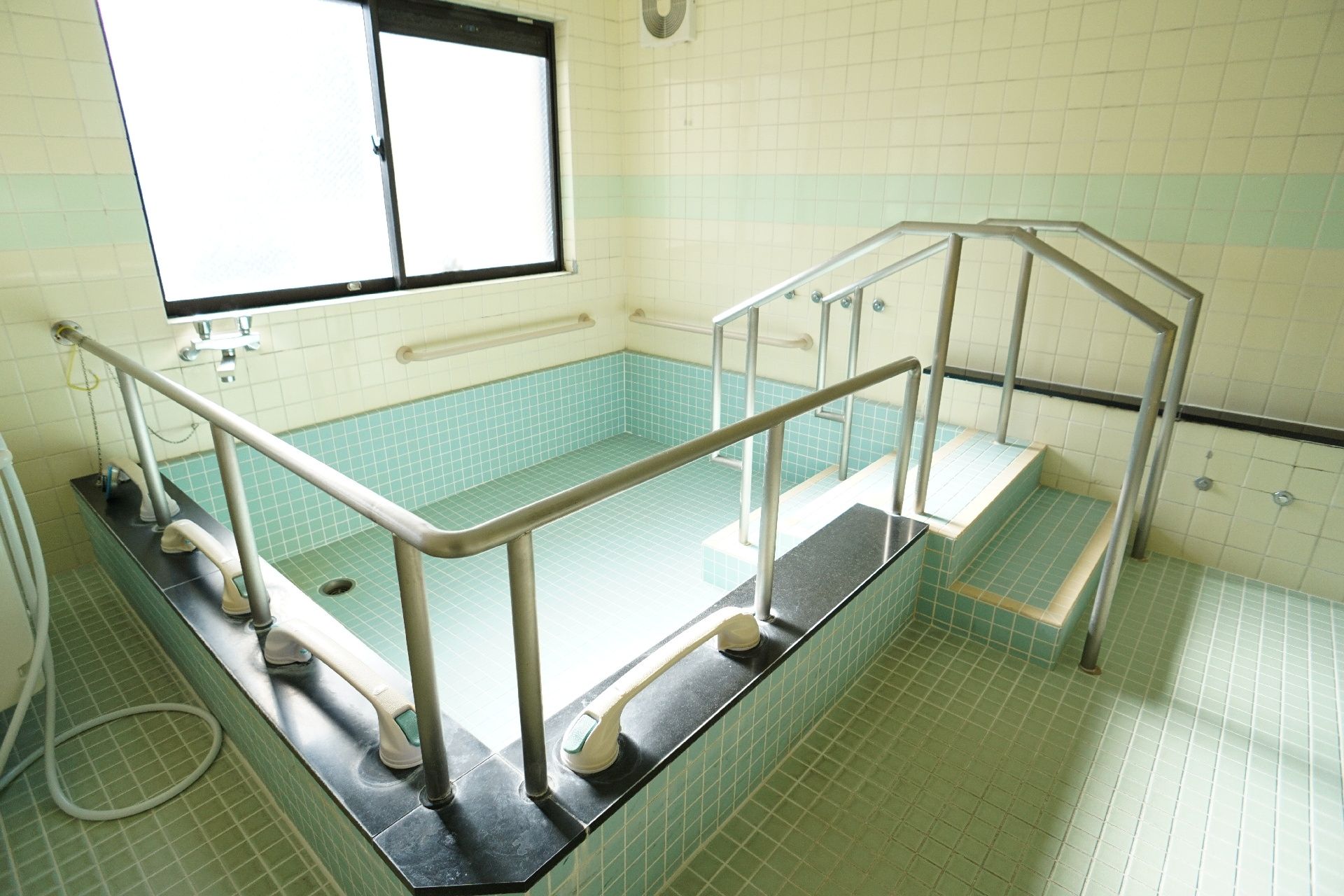 手すりが取り付けられ、滑りにくい床材が使われている浴室