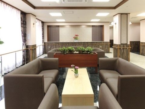 「サニーライフ松戸」のホール。こげ茶色のソファーが、落ち着きある色味を引き出している。