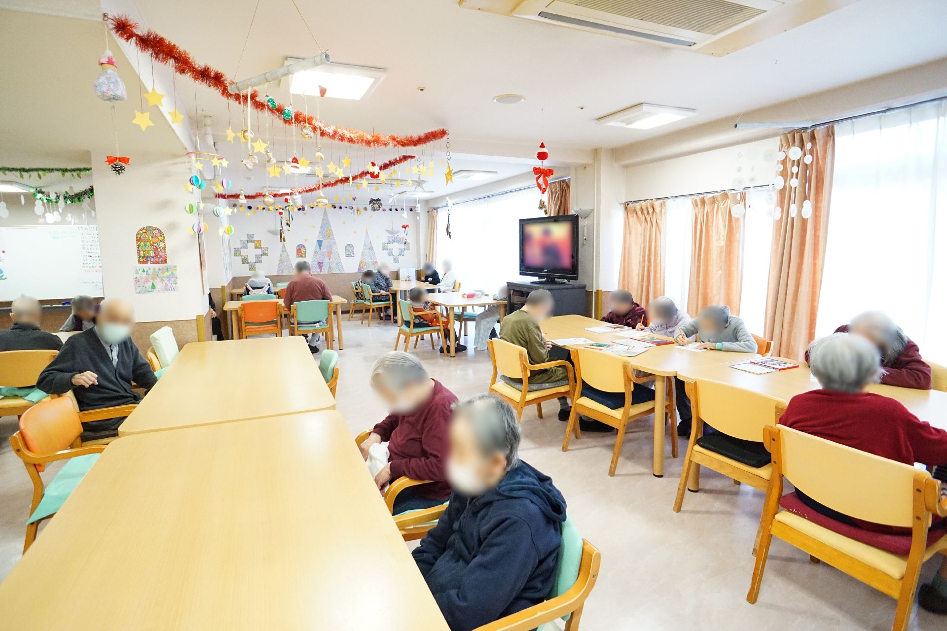 薬を飲む高齢女性と水を差し出す女性スタッフ