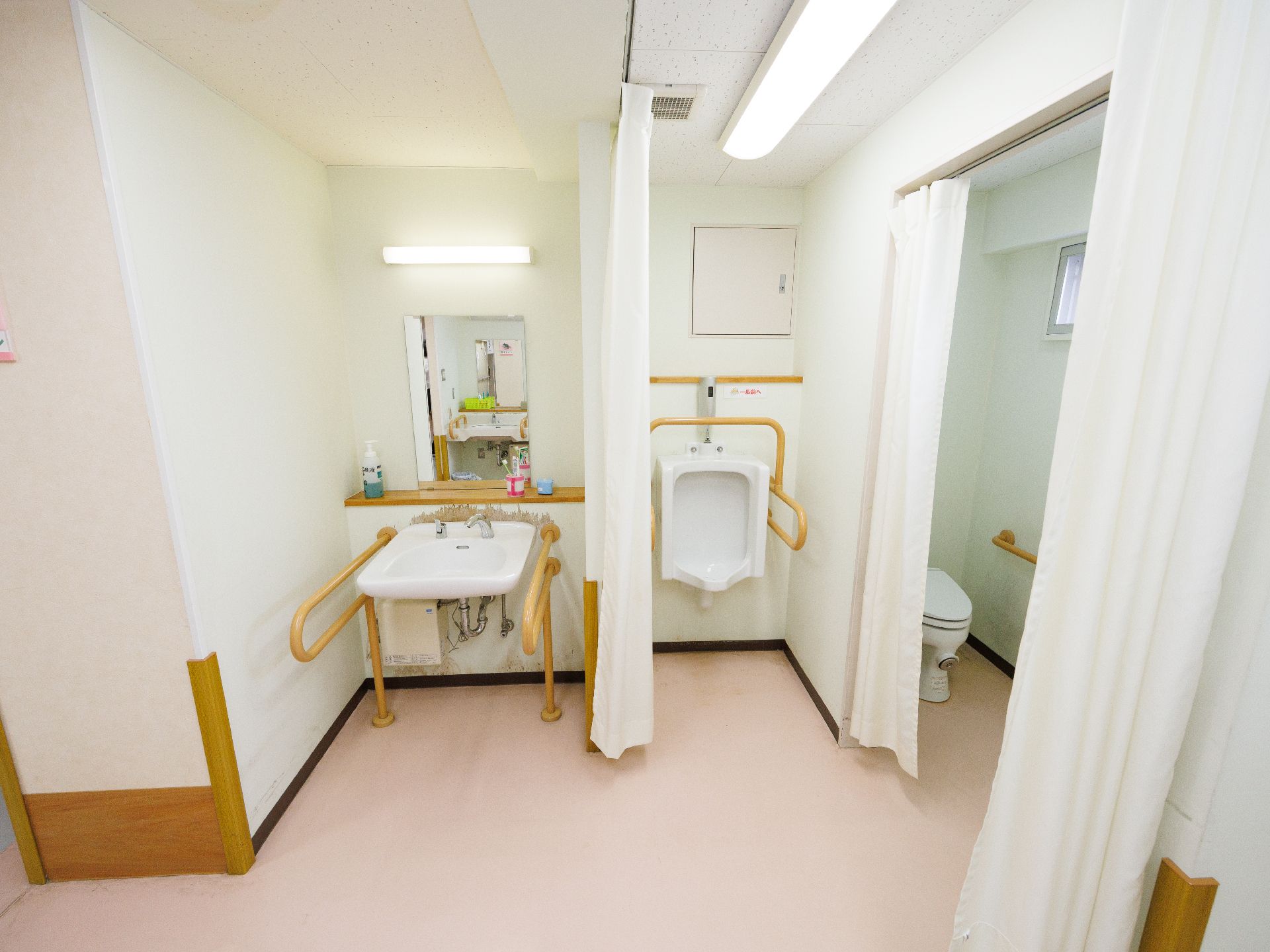 洗面台と小便器と洋式便器があるトイレに