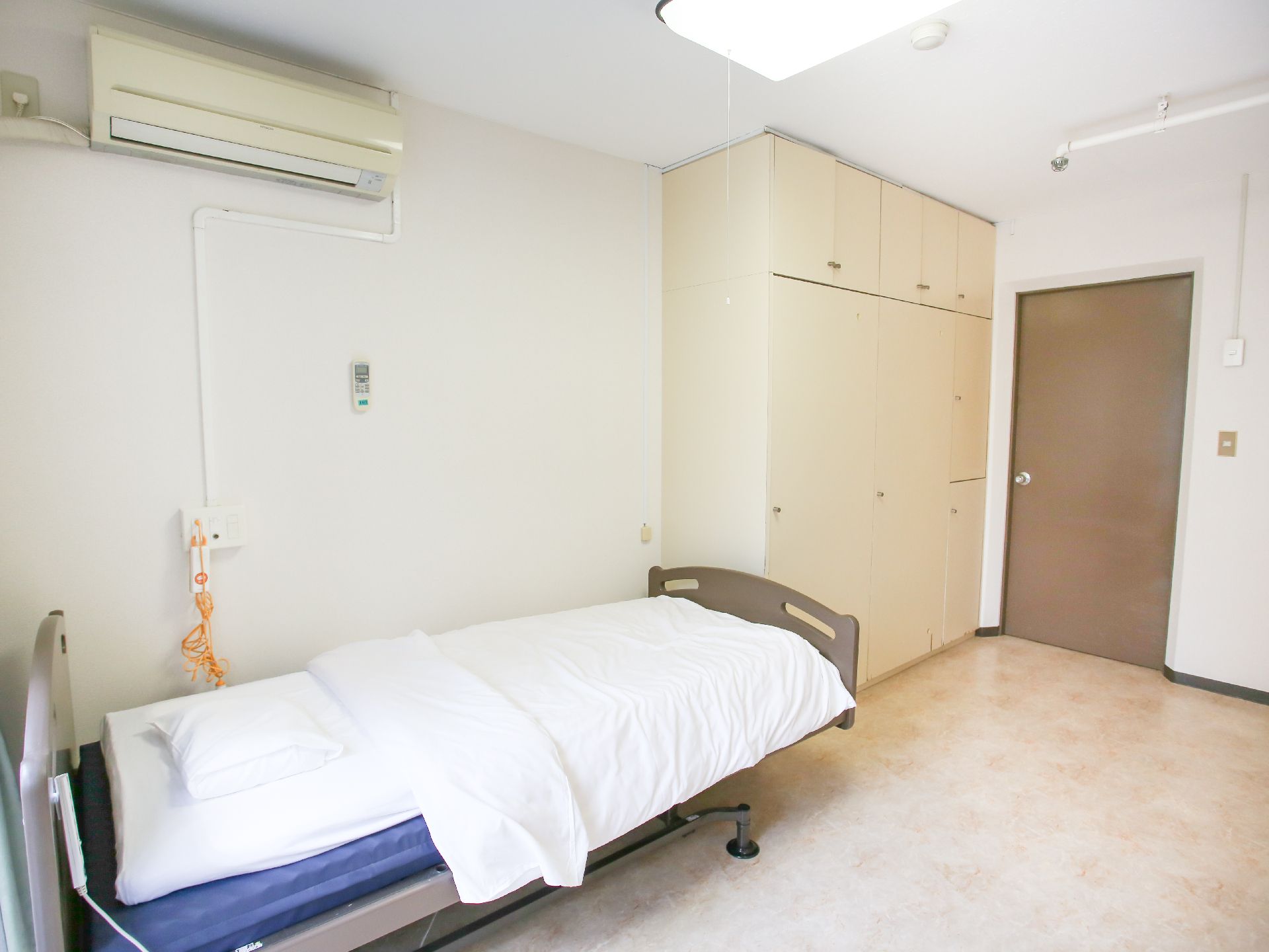 介護ベッドが置かれ、引き戸のドアが設置されている居室