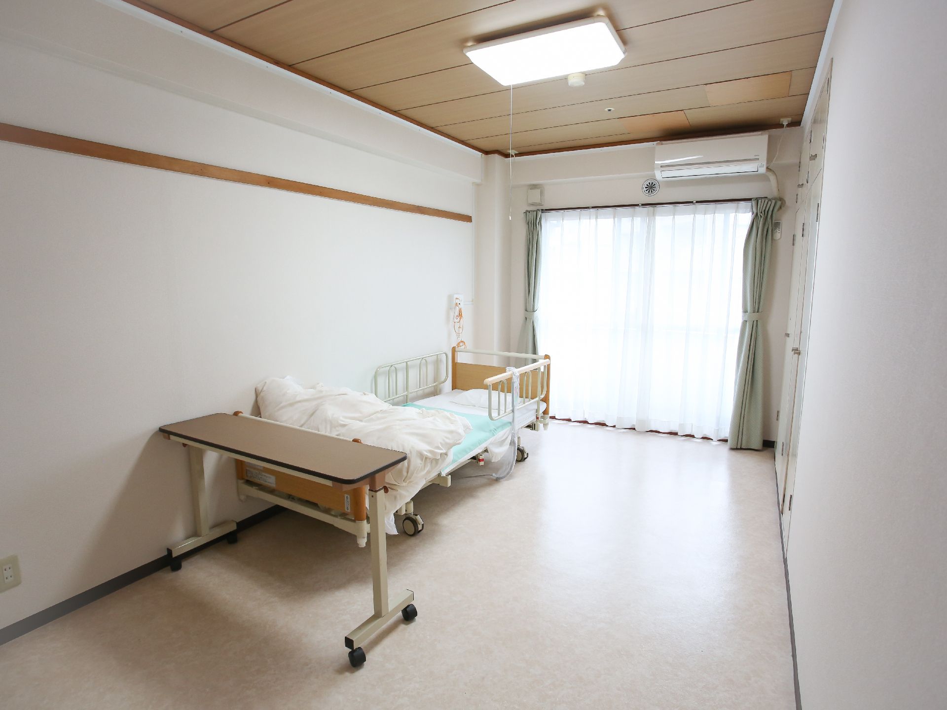 窓から陽光が入り、介護ベッドが設置されている居室