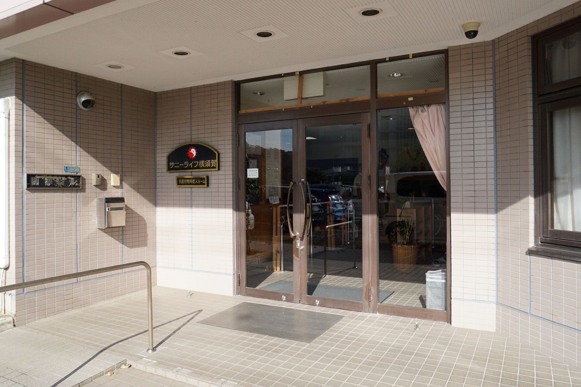 入口の隣に看板がついている玄関