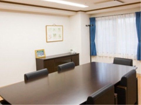 黒いテーブルセットが配置されている、白い壁紙の部屋