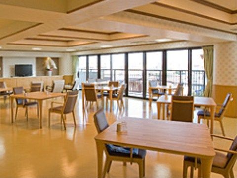 天井からの大きな掃き出し窓がある広い室内に、二人掛けのダイニングセットが間を空けて置かれている。窓の外にはベランダが見える。