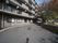４階建ての建物が写っており、部屋がたくさんある様子がわかる。その手前には車がゆとりを持って走れるくらいの広さの道路がある。