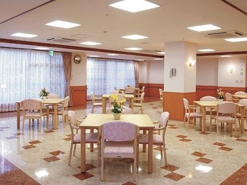 花が飾られたテーブルと椅子が複数設置された食堂