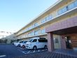 施設の前に車が数台停まっている様子の外観