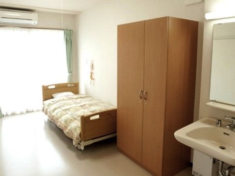 ベッドとタンスが設置された居室