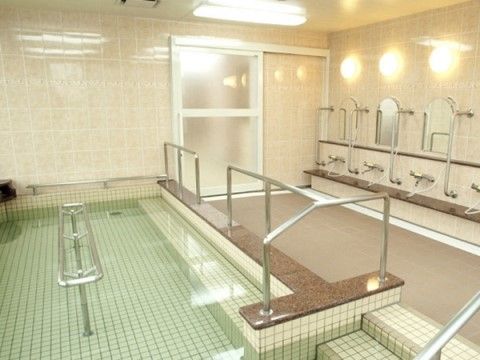 大きな浴槽と複数のシャワーが設置された大浴場