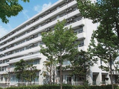 サニーライフ神戸の外観。整然と並ぶ木々に囲まれた緑豊かな施設です。