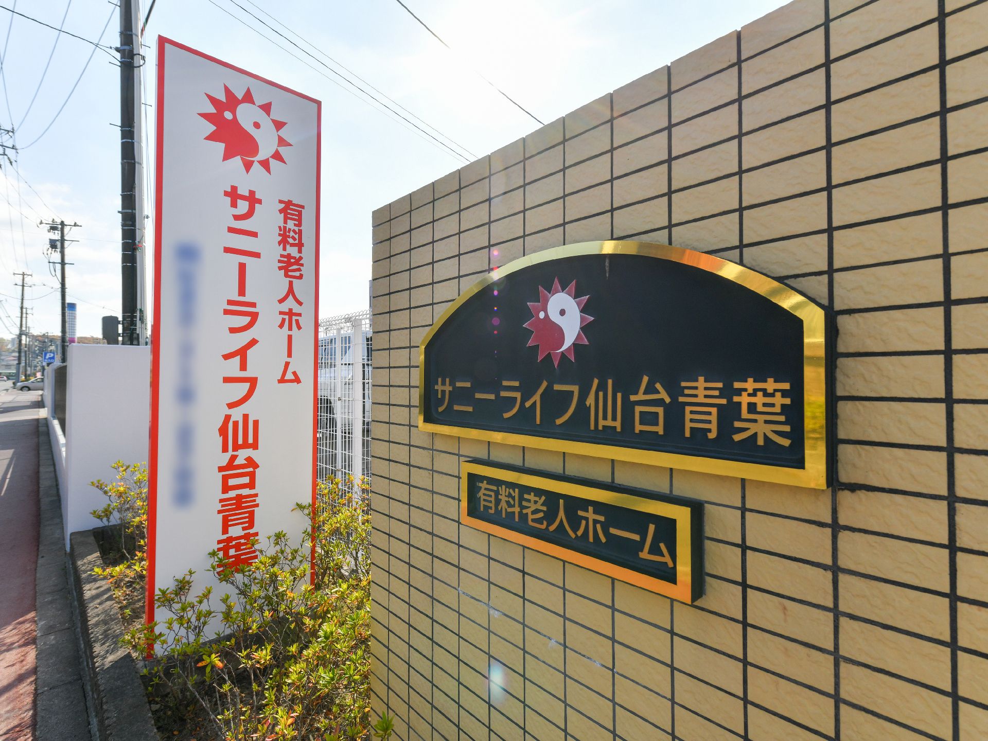 車椅子に座っている高齢女性と笑顔で寄り添う女性ヘルパー