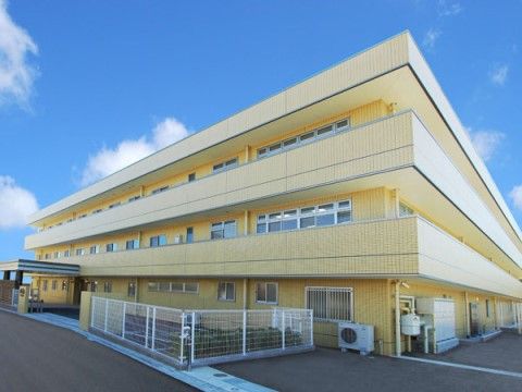 サニーライフ名古屋南の外観。レモンイエローの明るい外壁にしっかりとした印象を与える介護向け安心設計の建物です。