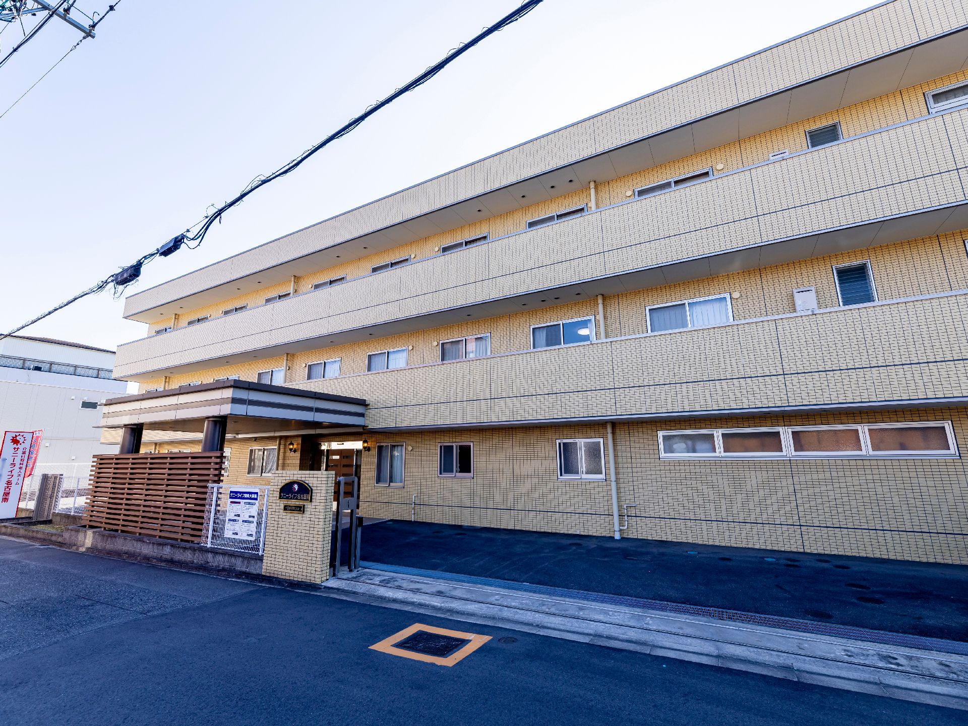 介護車両へ移動する車椅子に乗った高齢女性と介助をする女性ヘルパー