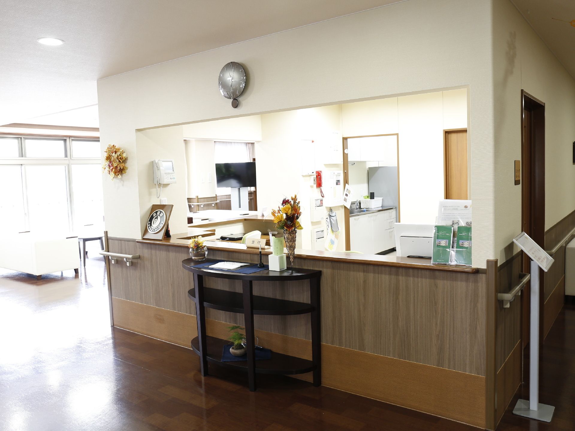 木目調を基本とした広い窓口である。壁にはてすりが設置されている。明かりがたくさん入る空間にはソファーやテーブルが設置されている。