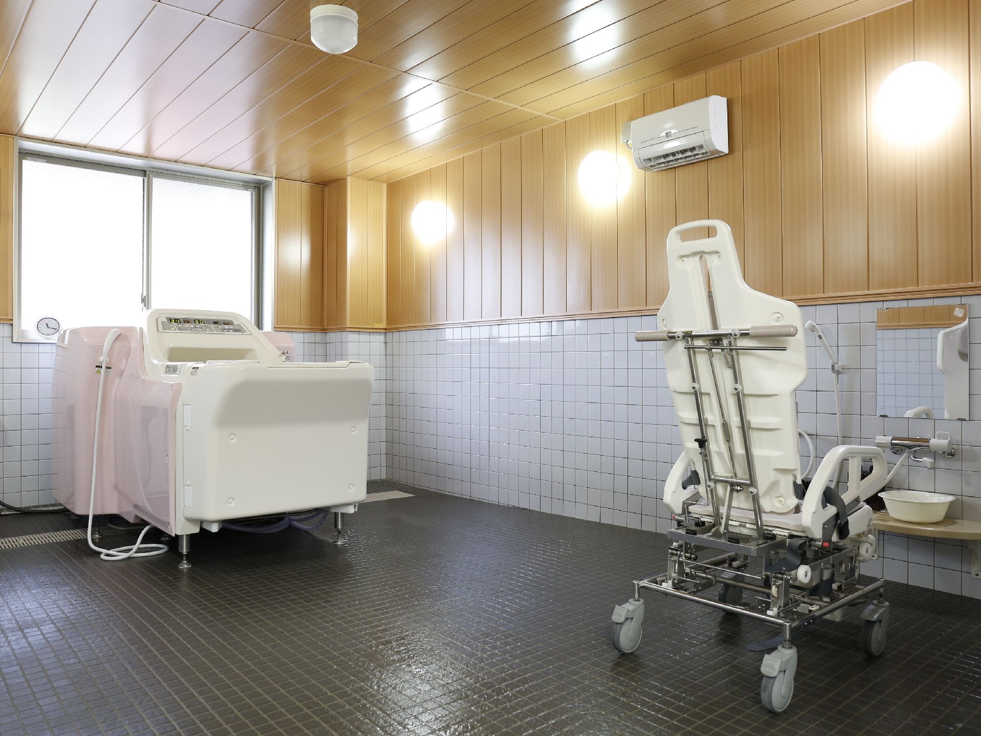 施設利用者のお風呂場である。座ったまま移動できる椅子が設置され、移動にゆとりがあるスペースを確保している。またエアコンがついている。