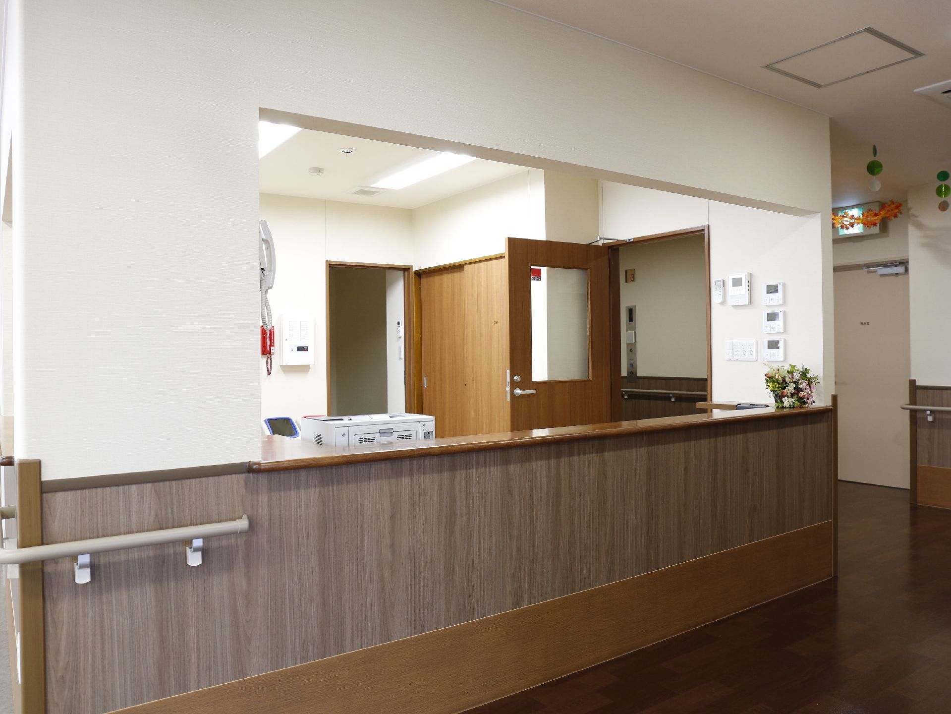 スタッフと利用者がカウンター越しに話しがしやすい大きな窓口である。利用者側には足腰の弱い利用者が使用できる手すりがついている。