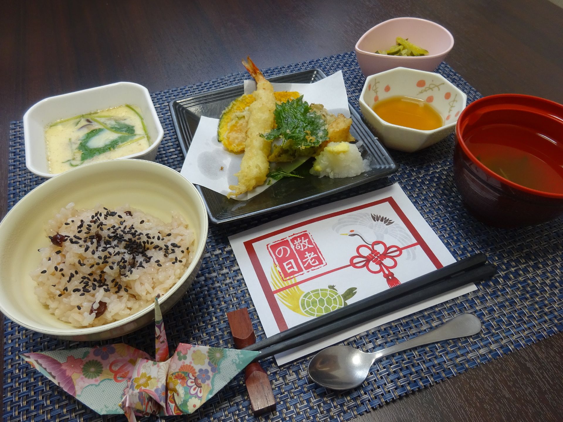 赤飯、天ぷら、吸い物、茶わん蒸しがお盆に載った敬老の日の祝い膳
