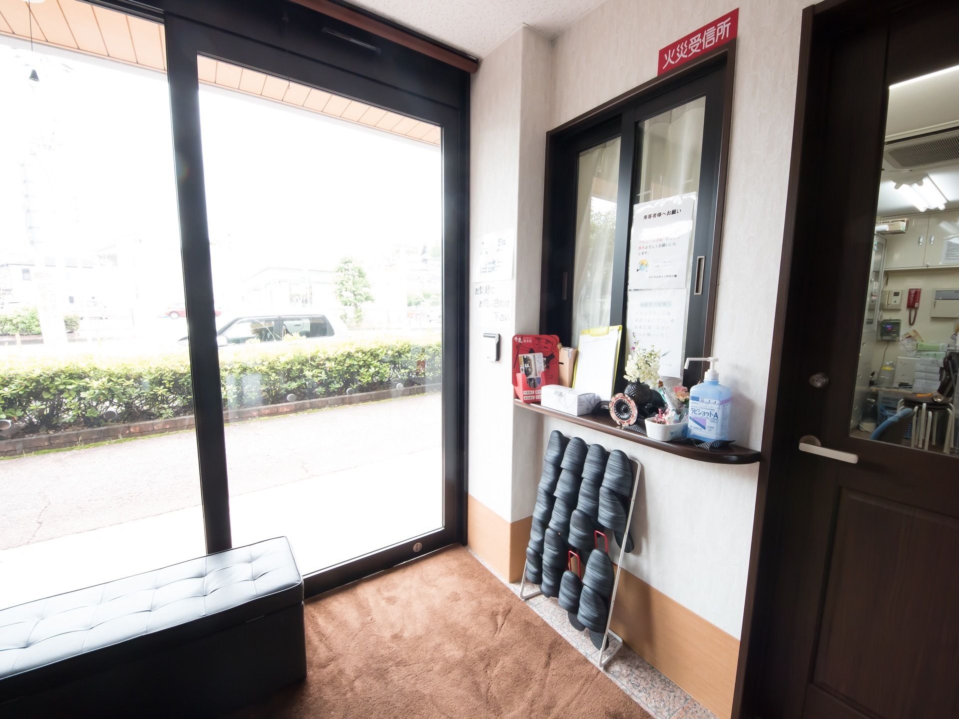 施設の玄関口。受付窓口は閉め切られており、記帳は来訪者自身が行う。カウンターの下にはスリッパ立てがある。