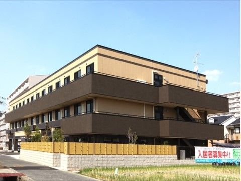 和泉寺田の郷の外観。黄色と茶色が暖かな雰囲気を醸している施設外観。来訪用の駐車スペースを確保しております。