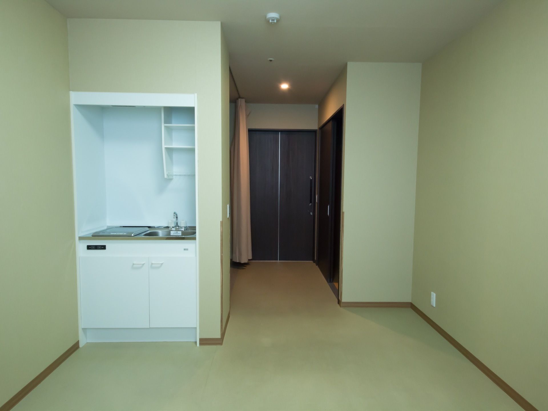 居室には、ミニキッチンがある。洗い場と電気コンロが設置されている。洗い場の下は収納スペースとなっている。