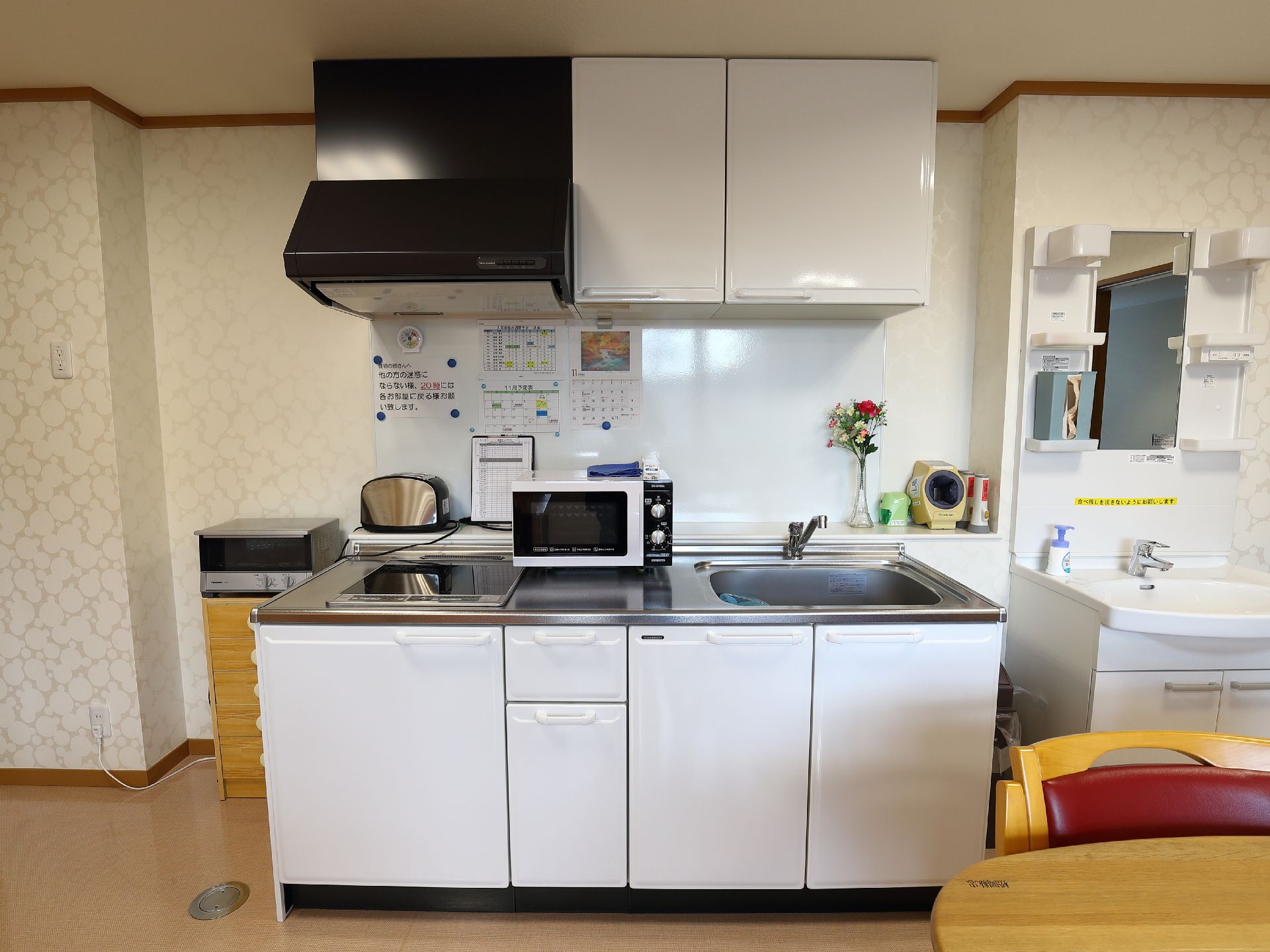 キッチンの近くには食堂があり、テーブルと椅子、ソファーなどが並べられている。天井にはカラフルな輪飾りがかけられている。