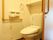 居室内に洋式トイレが設置されている。壁にはＬ字型の手すりがあり、立ち座りの際に体を支えながら安全に利用することができる。