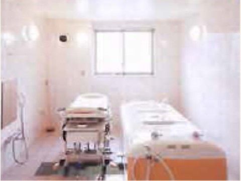 浴室内には、介護用の大きな浴槽と、施設のスタッフが操作をする介助装置が取り揃えられている。浴室中央の窓からは、日の光が差し込んでいる。