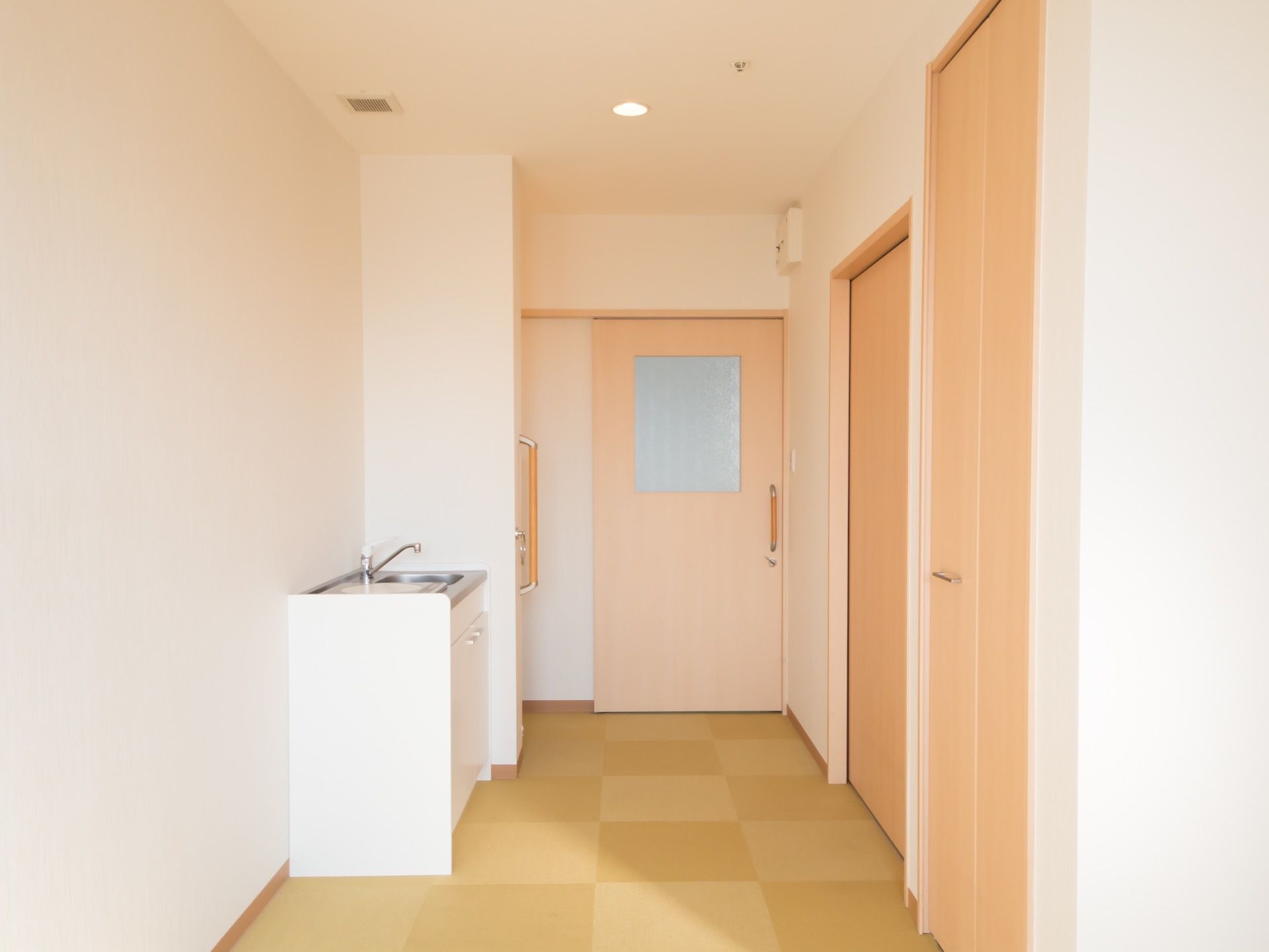 各居室の玄関側には水回り、および収納スペースが配置されている。ドアは引き戸式になっていて、くもりガラスの窓が取りつけてある。