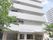 マンションが立ち並ぶ中に7階建てで建てられている施設の外観。グレーのレンガ調の外壁が落ち着いた雰囲気。