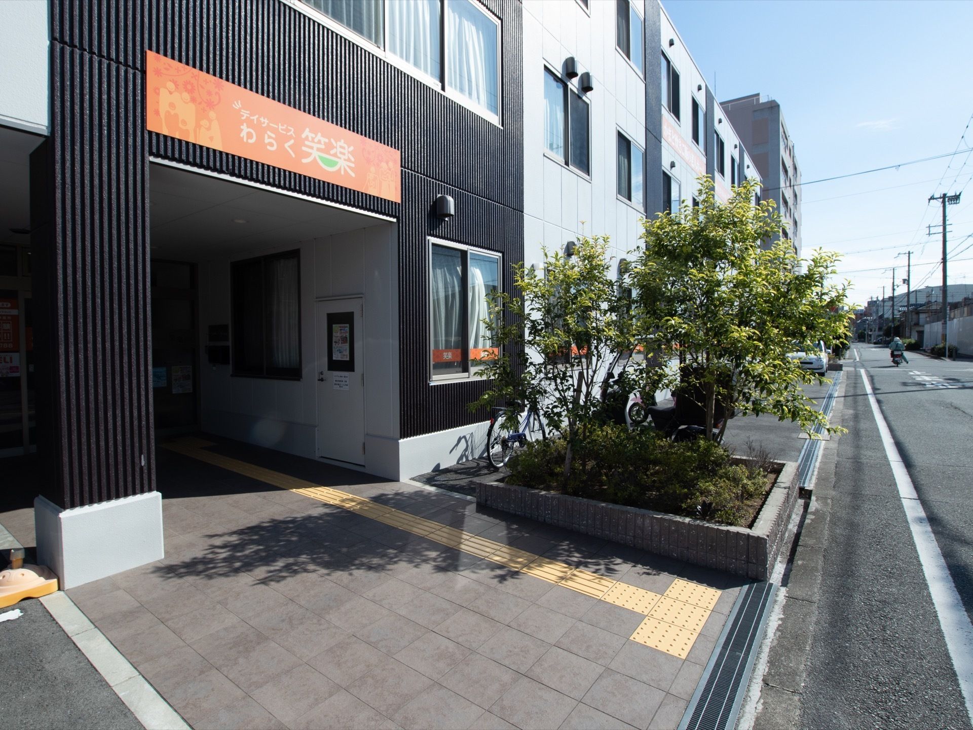 入口の壁は黒色で、玄関にはガラス張りの自動ドアが設置されている。右側には、スタッフの常駐する受付が設けられている。